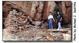 Students next to a wall at Woods Canyon Pueblo.